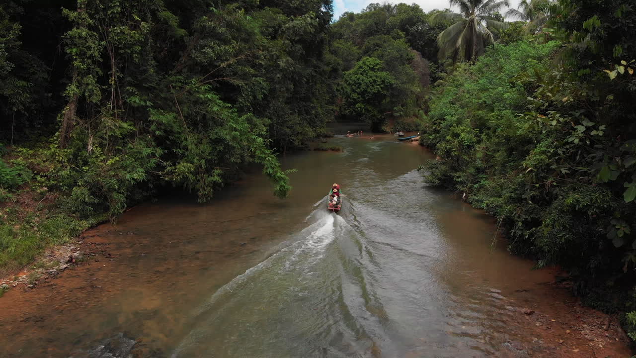 kampung sampan en un río rural al lado de una casa larga
