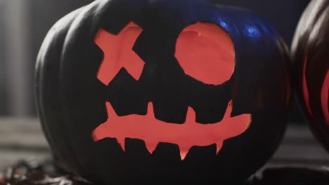 Video-of-halloween-carved-pumpkin-and-smoke-with-copy-space-on-dark-background