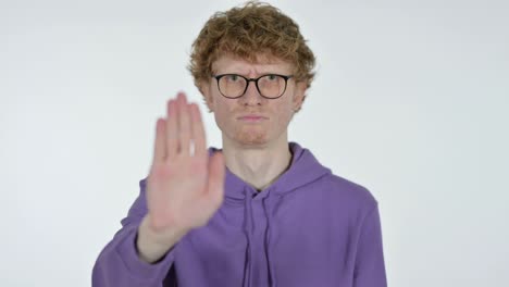 redhead young man with stop sign by hand, white background