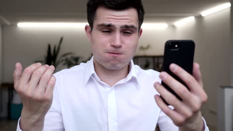 businessman using smartphone and reacting to loss