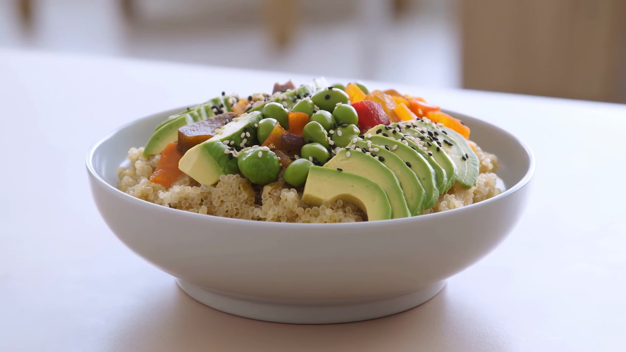 Frisk avokado-quinoabolle med edamame, skivet avokado, terninger av paprika, sesamfrø, luftig quinoabunn, fargerik
