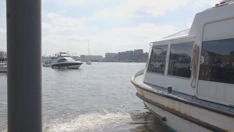 tourist boat leaving mooring at pier on river thames in london uk