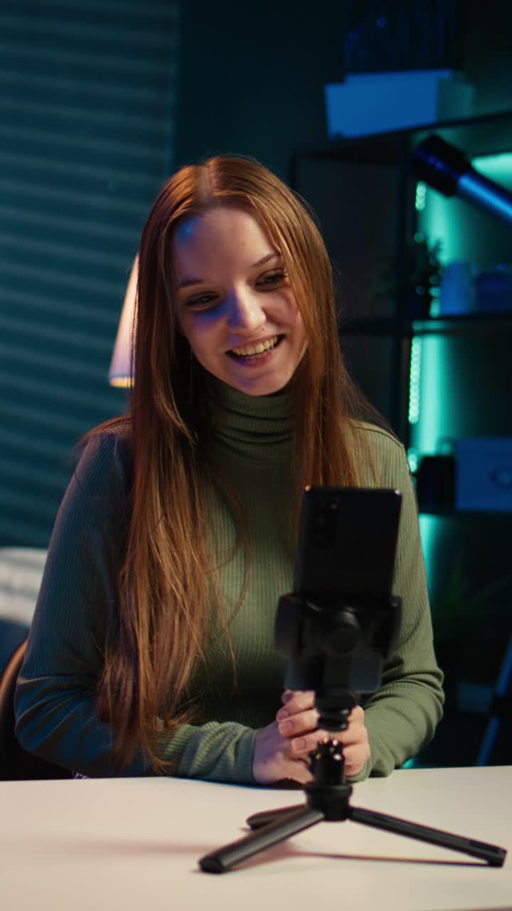 Giovane donna che registra un video con lo smartphone per i social media a casa