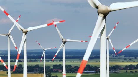 aerial tracking shot of wind power generators collecting energy on a windy day