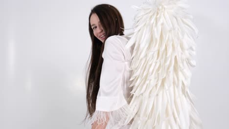 beautiful brunette girl with angel wings she poses in the studio beautiful brunette girl with angel wings she poses in the studio on a white background