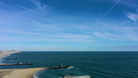 backward-aerial-footage-reveals-beach-with-a-long-dock-with-a-hut-on-a-gorgeous-sunny-day,-in-4K