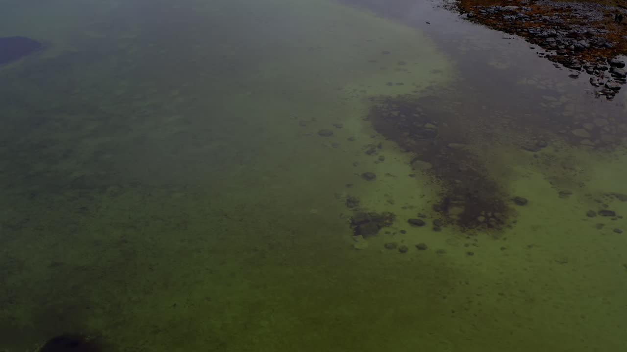 Drone in volo sopra un lago stagionale (turlough) che rivela la rete idrica sotterranea del Burren. Contea di Clare.