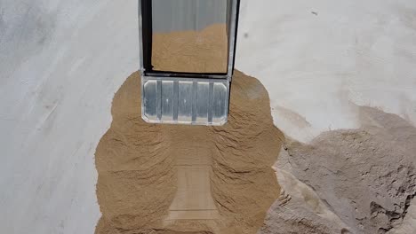 aerial view of a dump truck unloading sand at a concrete factory