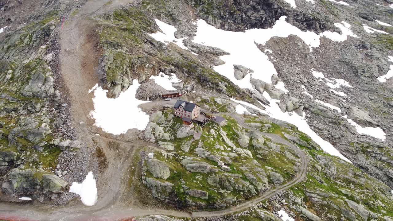 casa en un campo de piedra parcialmente cubierto de nieve en los alpes en kaernten, austria