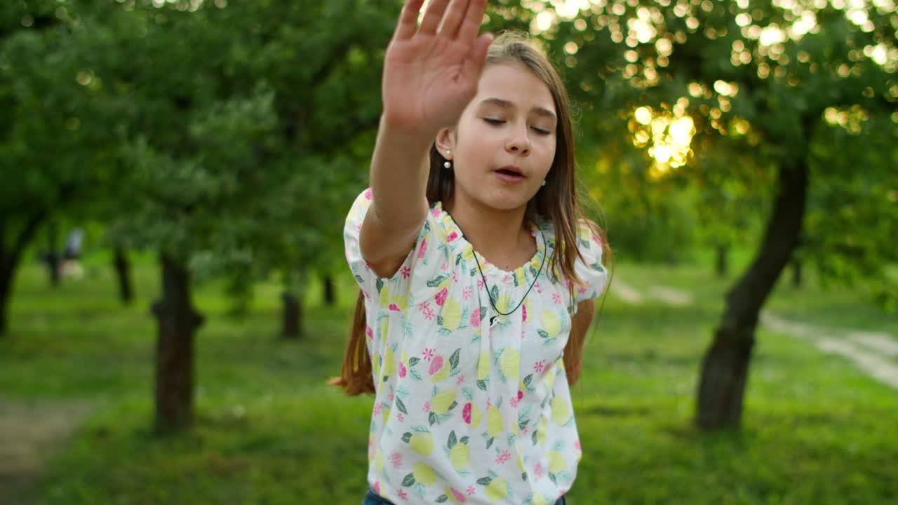 una adolescente seria bailando afuera