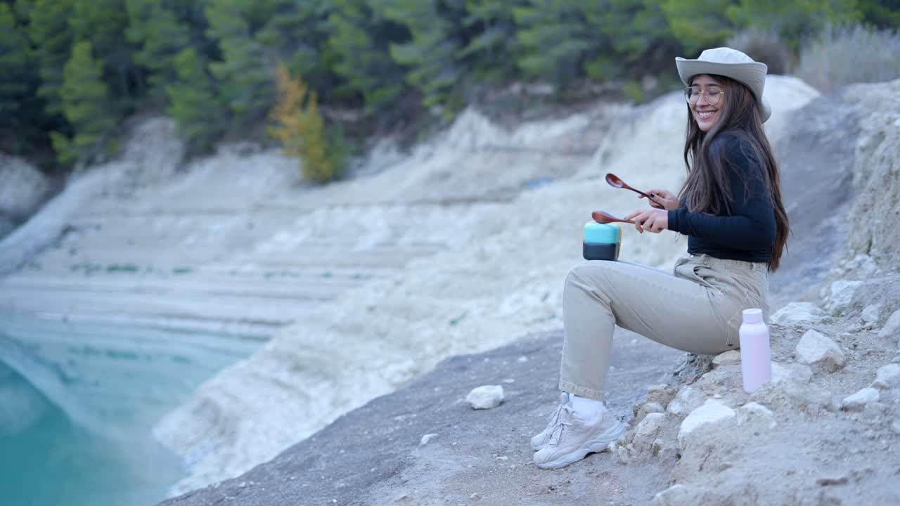 Woman playing percussion instruments by a lake
