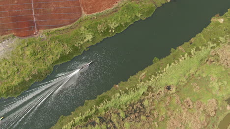 Aerial-top-down-shot-of-speeding-traditional-long-boat-on-channel-between-Inle-Lake-and-Moebyel-Lake,-Myanmar