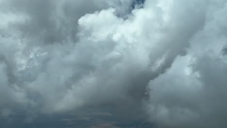 An-unique-pilot’s-perspective:-flying-trough-a-sky-full-of-tiny-cumulus-clouds,-recorded-from-a-jet-cabin-while-flying-at-9000m-high