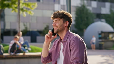 happy man speaking mobile phone on street closeup. handsome young businessman