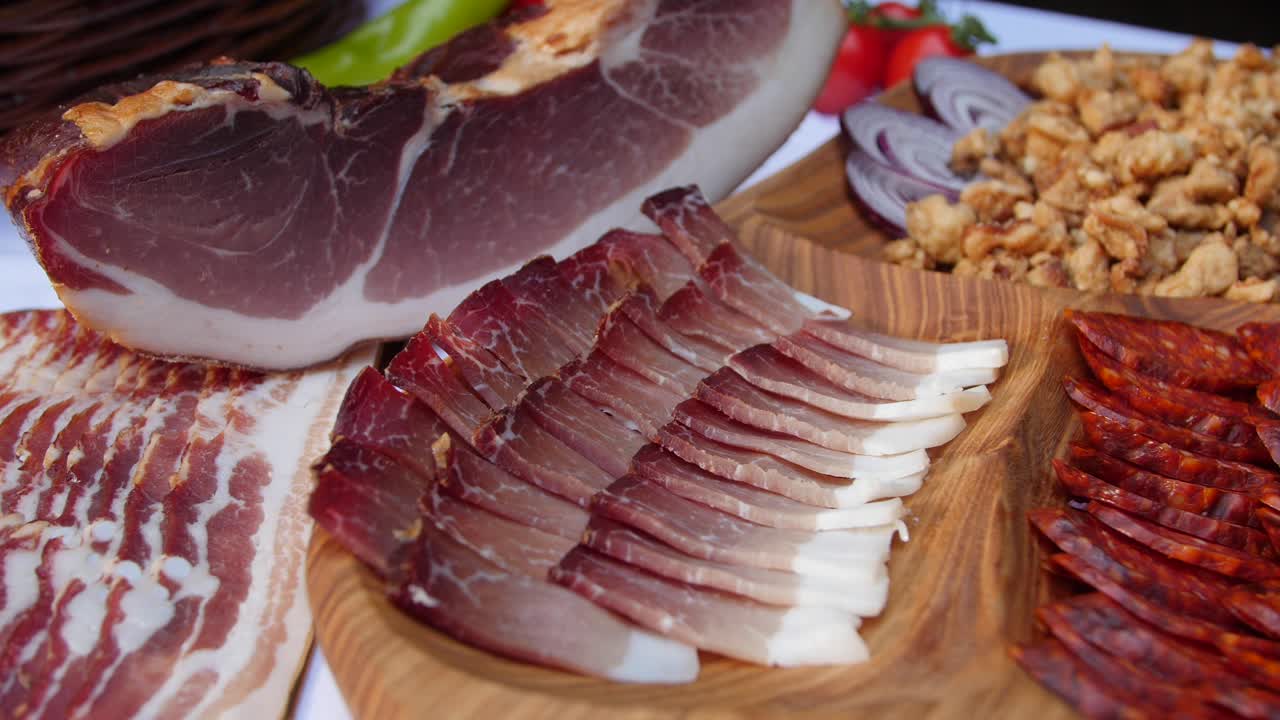 Mouthwatering bacon slices served on platter sorrounded by pork meat products. Zoom in