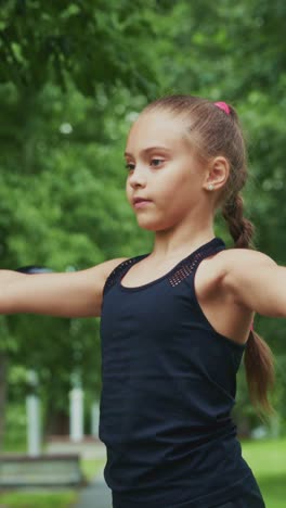 a young girl with confidence perfects her focus and balance in a serene outdoor setting surrounded by lush greenery and natural beauty