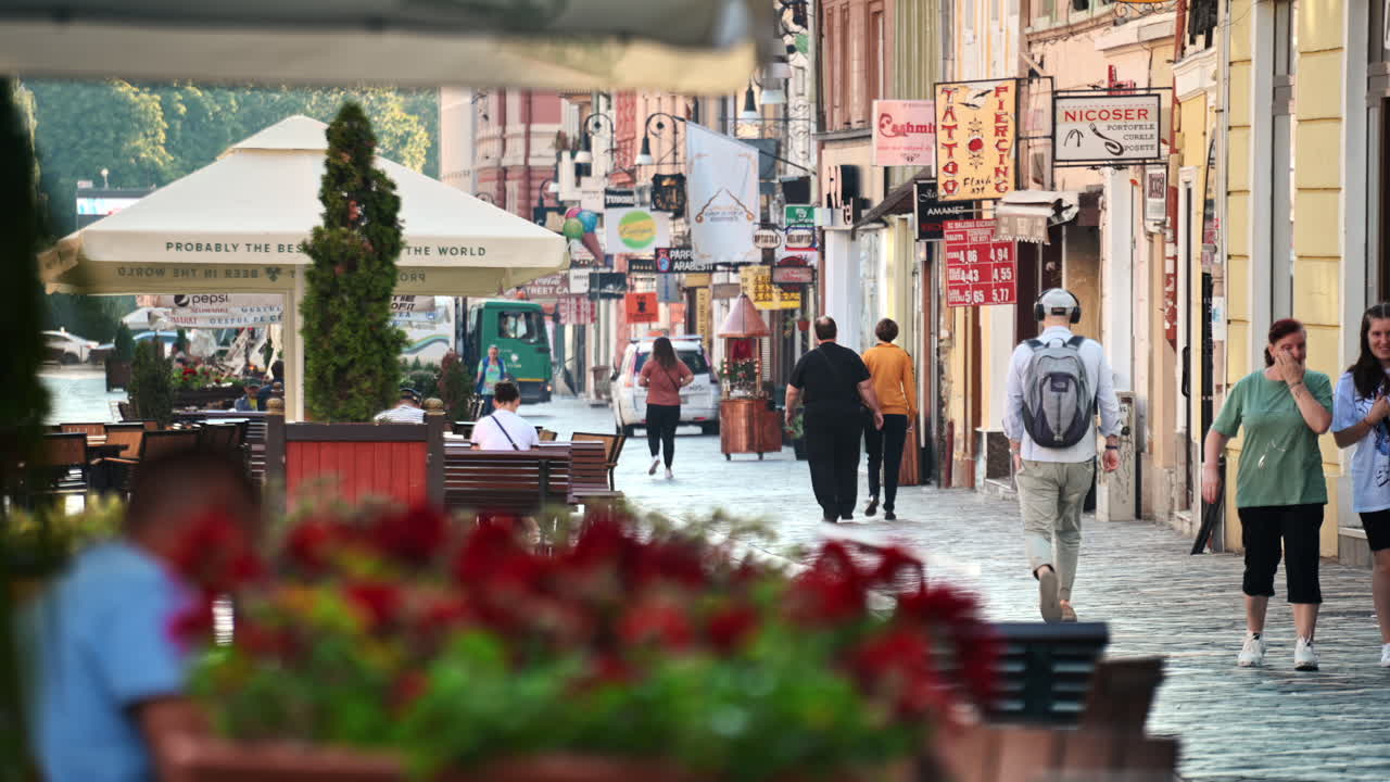 BRASOV, ROMANIA - AUGUST 27, 2023: Street view of the town. Old buildings and walking people