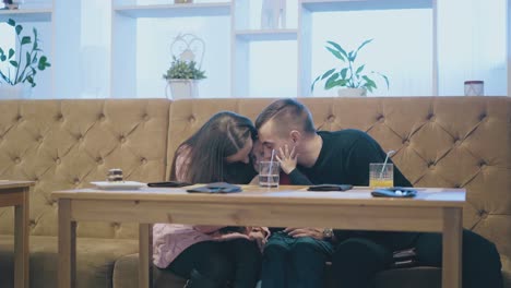 행운의 부모는 식당에 앉아 있는 아이를 안아주고 키스합니다.