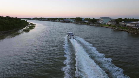 drone shot following boat driving on the matagorda canal, sunset in texas, usa