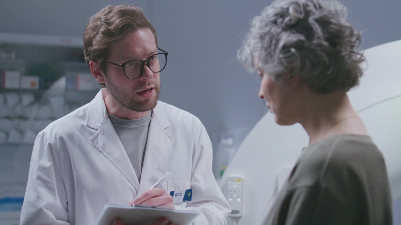 Male Doctor Discussing CT Scan Results with Senior Female Patient