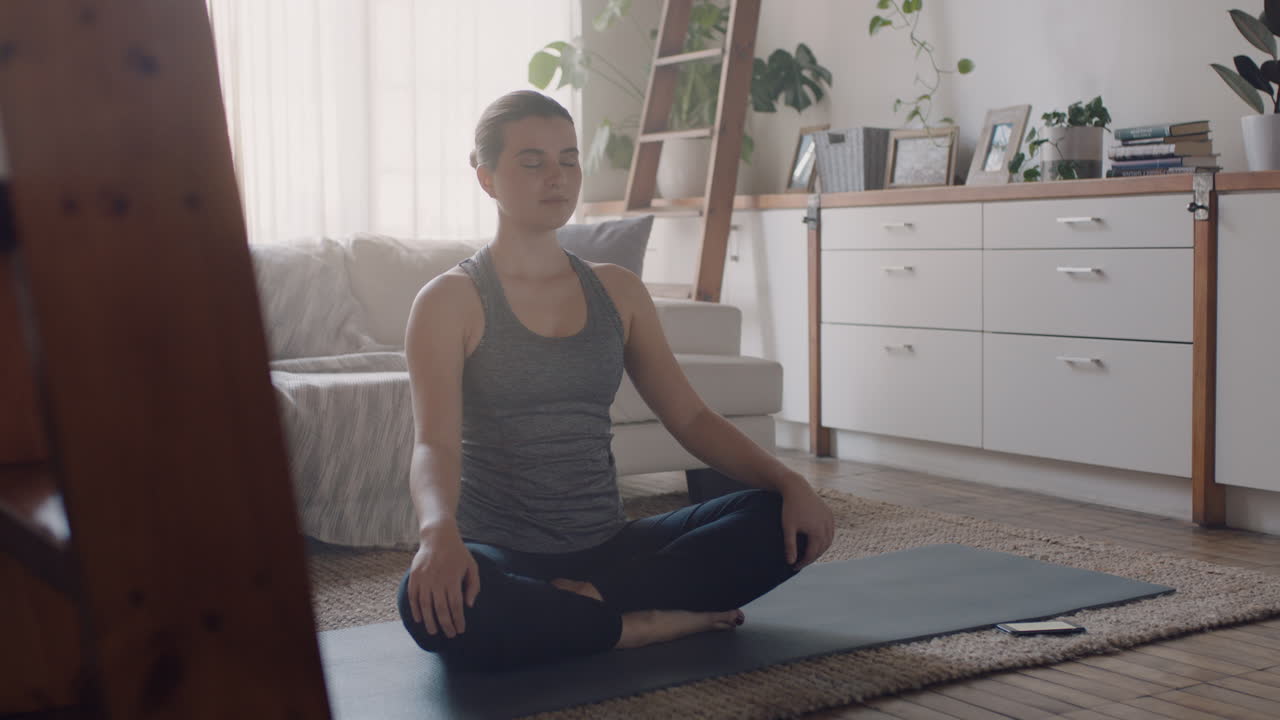 mujer de yoga saludable haciendo ejercicio en casa practicando meditación en la sala de estar disfrutando del ejercicio de atención plena por la mañana