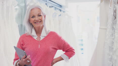 retrato de la propietaria de una tienda de vestidos de novia con una tableta digital