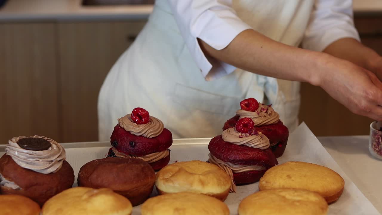 Crop baker sprinkling sponge cakes with decorations