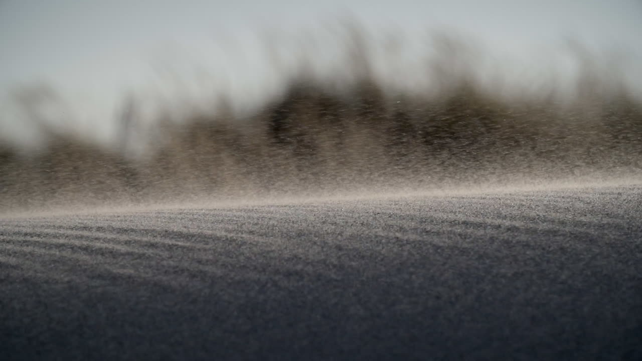 Sand blows over a sand dune, extreme closeup