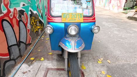 callejón de bangkok con tuk-tuk y graffiti