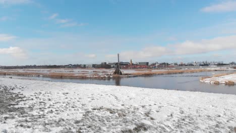 Snowy-winter-Dutch-windmill-polder-land-near-highway,-aerial-view