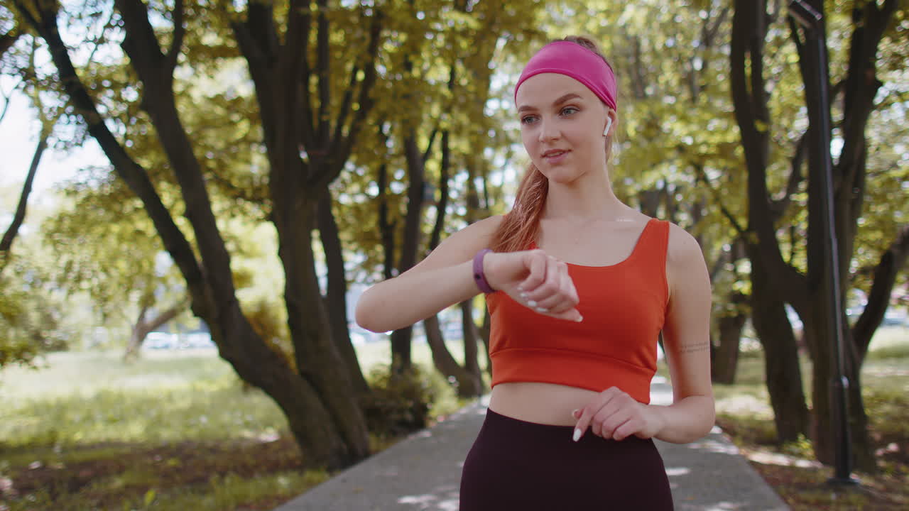 corredora atlética chica mira el reloj inteligente reloj dispositivo pulsera de fitness comprobación del tiempo, ritmo cardíaco