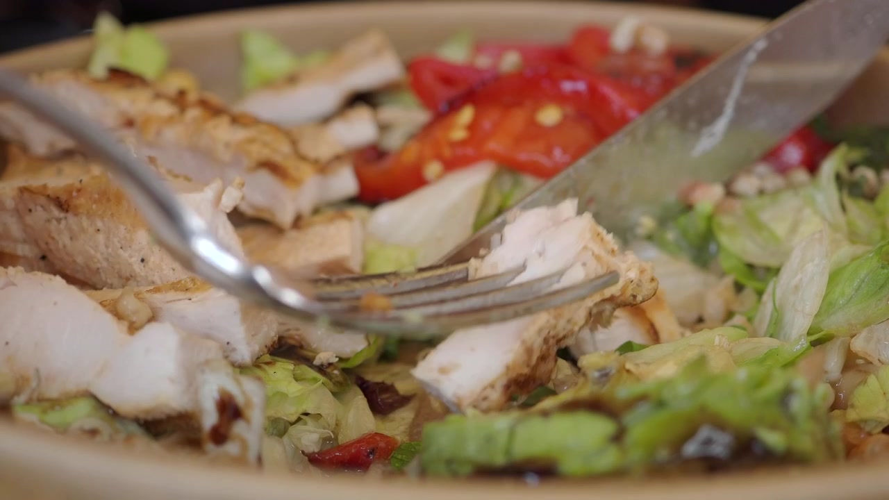 Taglio di pollo alla griglia in una ciotola di insalata fresca di verdure