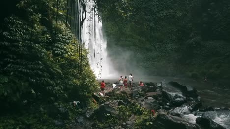 bali, spring 2020 in 1080 60p, daytime, cinematic drone flight slow motion flight in front of the waterfall over the river from left to right you see a small group tourists