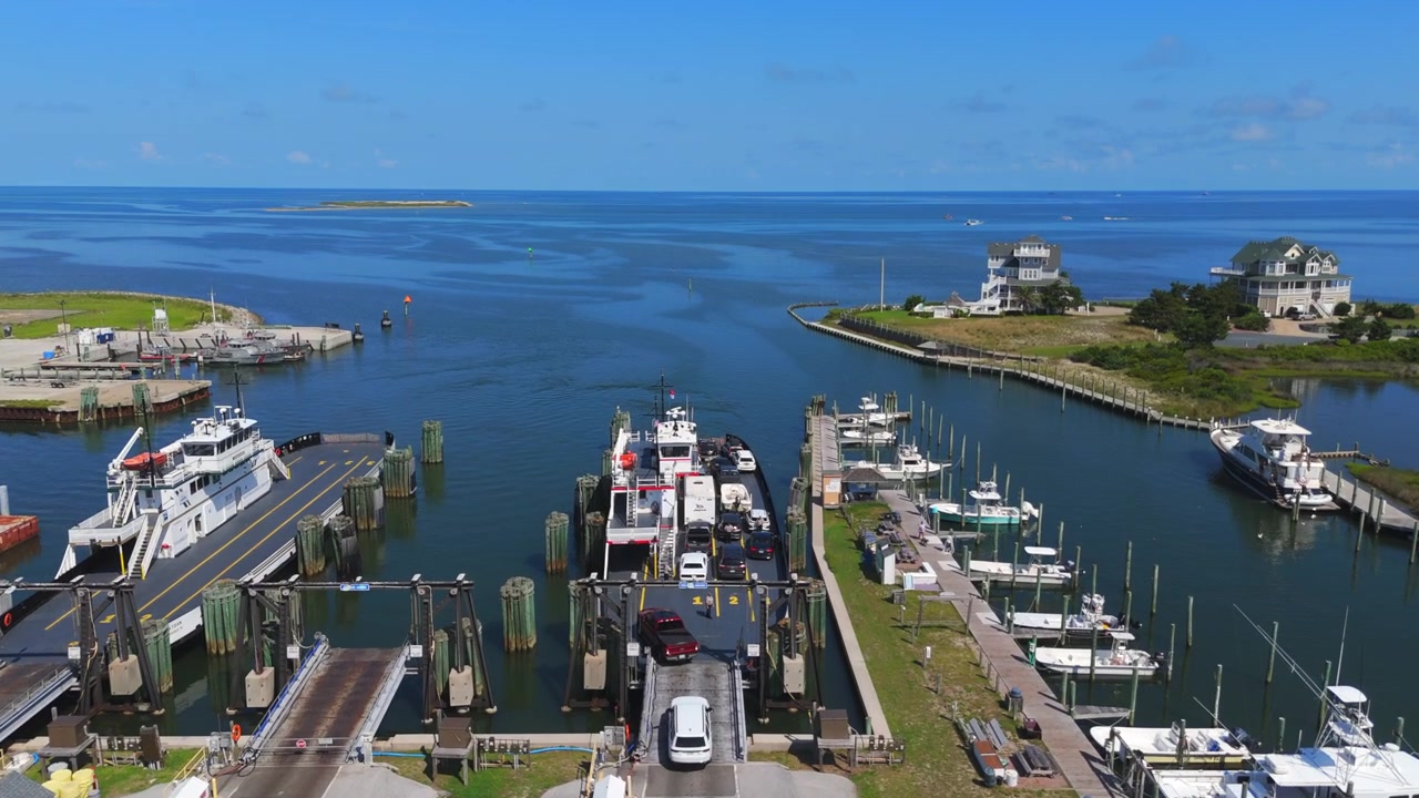 Terminal dei traghetti di Hatteras-Ocracoke sull'isola di Hatteras nelle Outer Banks della Carolina del Nord, USA, che mostra il terminal, i moli, l'acqua circostante e il paesaggio costiero - ripresa con drone