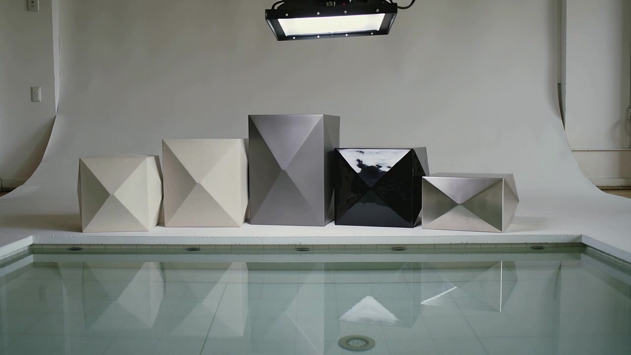 Lowering overhead light, five boxes casting moving highlights for defined reflections on water tank
