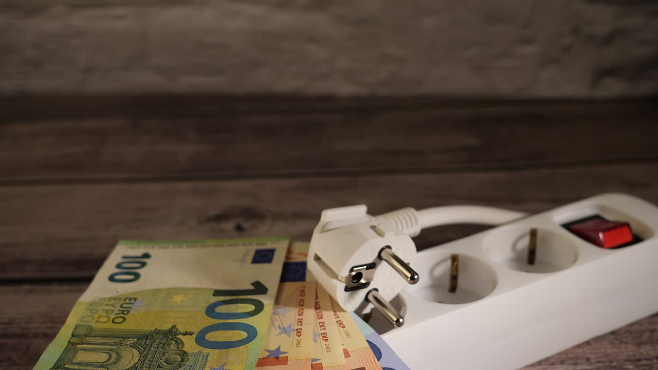 Kontanter på en forlængerledning, der viser konceptet med høje elpriser. Kopiplads