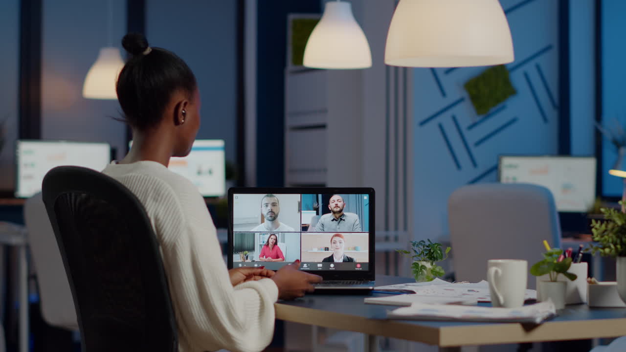African employee working overtime from business office late at night discussing