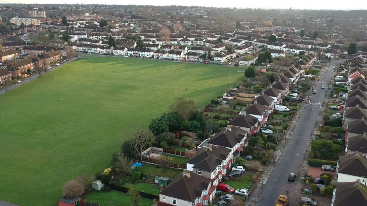 Aerial View of Mottingham, South East London: Terrace Houses, Green Space, and Dog Walker on Quiet Road
