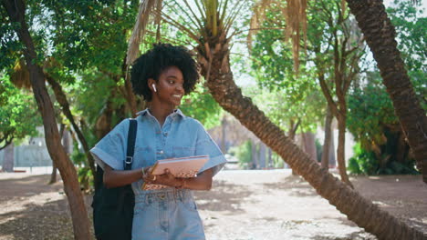 student in a park with books