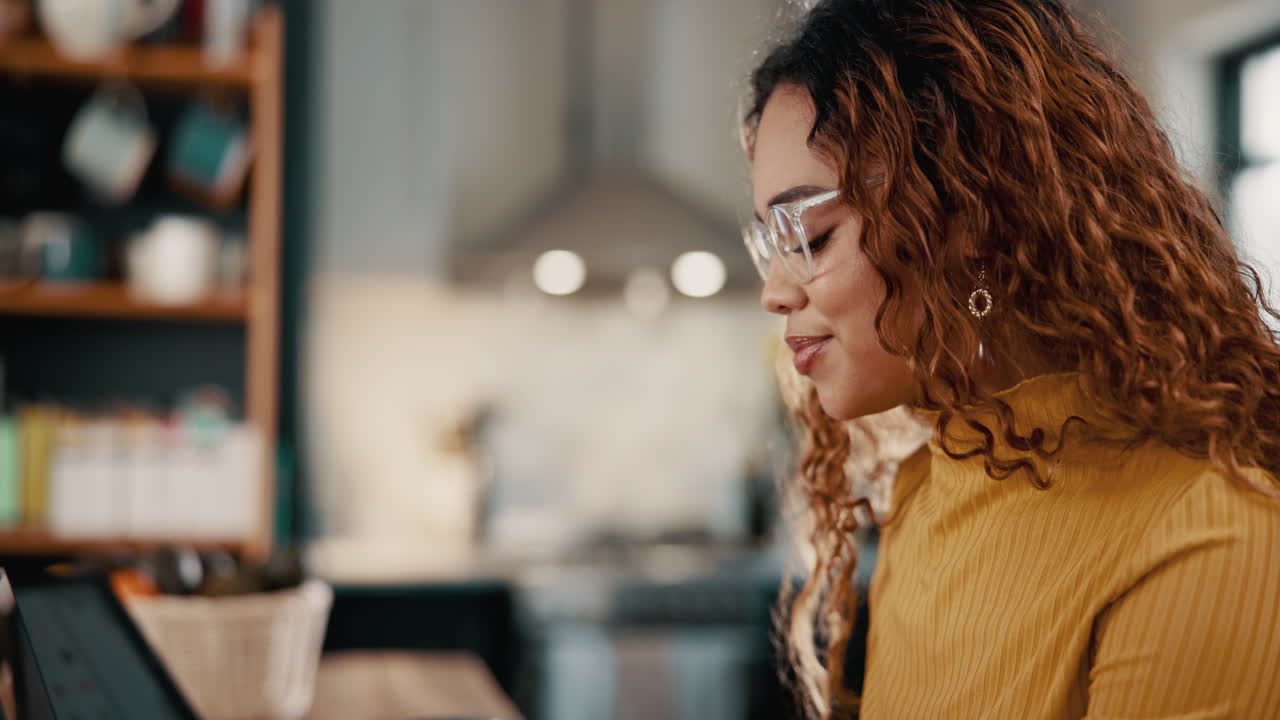 Young woman with curly hair and glasses looking thoughtful