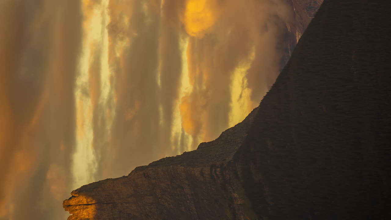 lapso de tiempo vertical de 4k, picos altos y nubes impresionantes en el paisaje montañoso a la luz del sol al atardecer