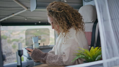 woman reading cellphone message in trailer van closeup. lady looking smartphone