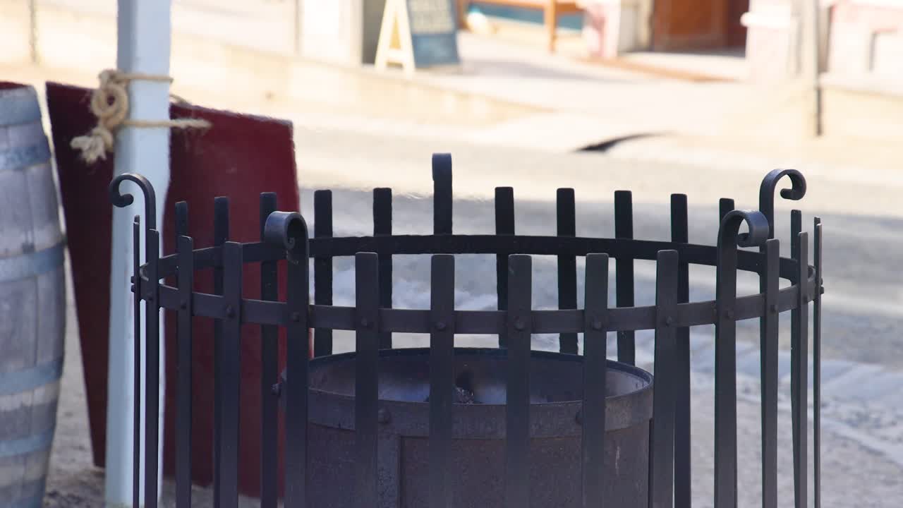 A static view of an iron fire pit surrounded by historical architecture in Ballarat, Australia, under natural daylight