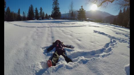 kid making snow angels in snow during winter 4k