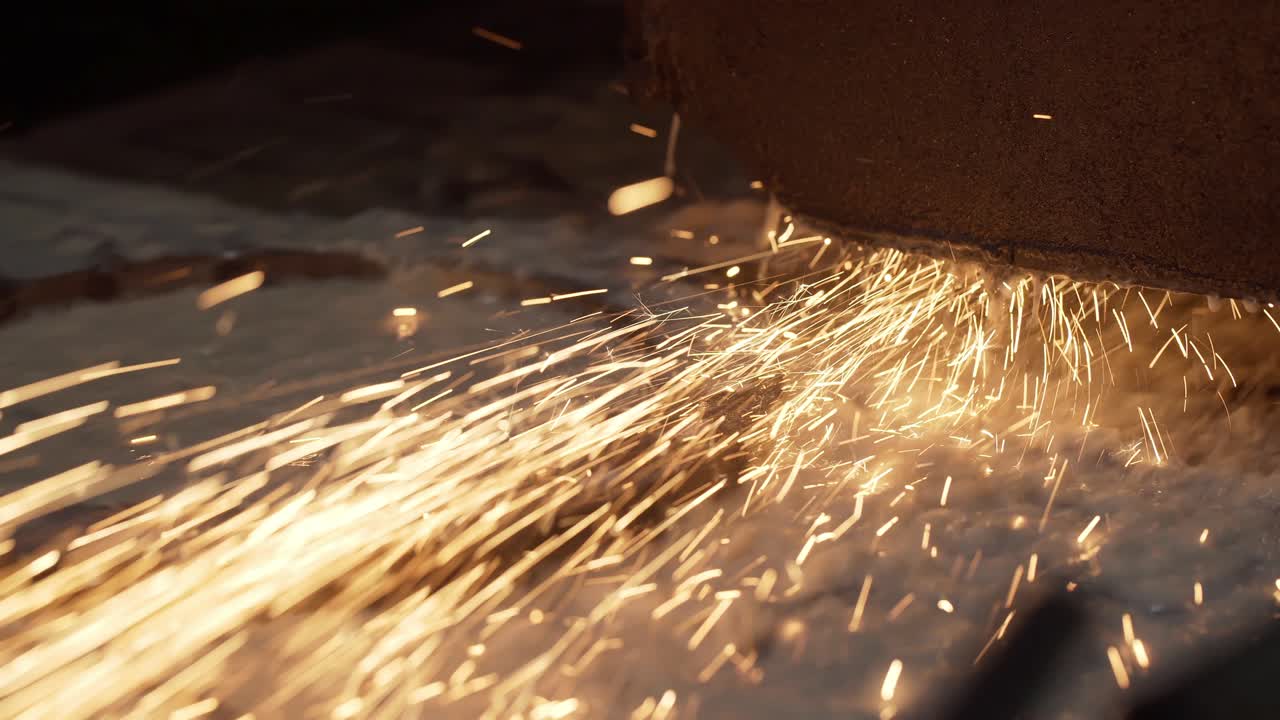 Funken einer Metallschleifmaschine. Industrielles Schleifen von Metall mit Funken. Metallfräsmaschine beim Bearbeiten eines Metallteils in der Fabrik. Metallbearbeitung mit Funken.