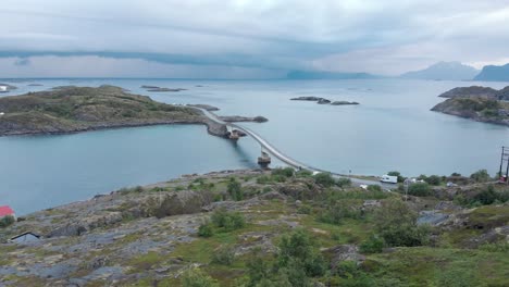 Camping-tent-on-a-slope-at-Henningsvaer-fishing-town-On-Lofoten-Archipelago,-Norway---Overtake-reveal-aerial-shot