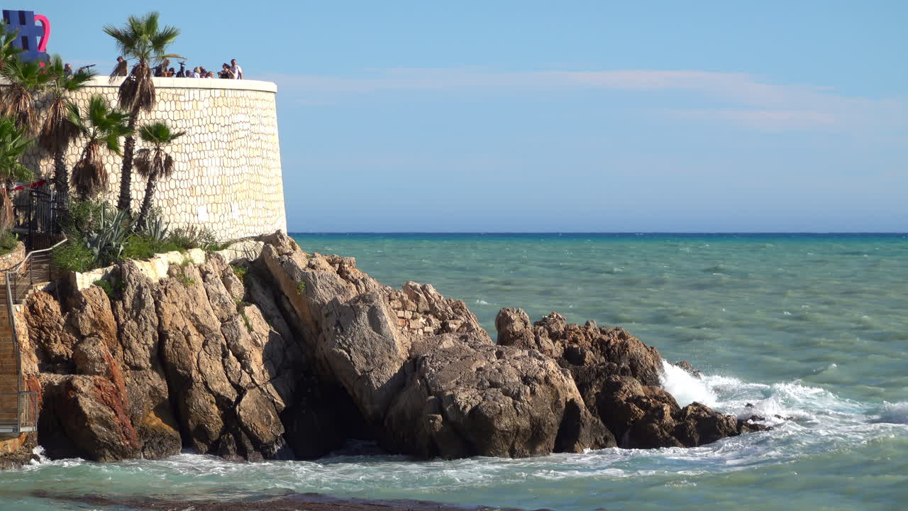 Nice, France - July 3, 2025: View of the I Love Nice sign on the Promenade des Anglais, with tourists enjoying the lookout and a passenger boat cruising across the Mediterranean Sea