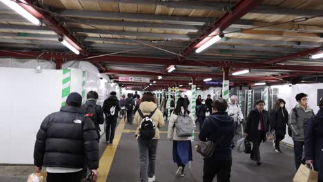 people walking through a subway station corridor