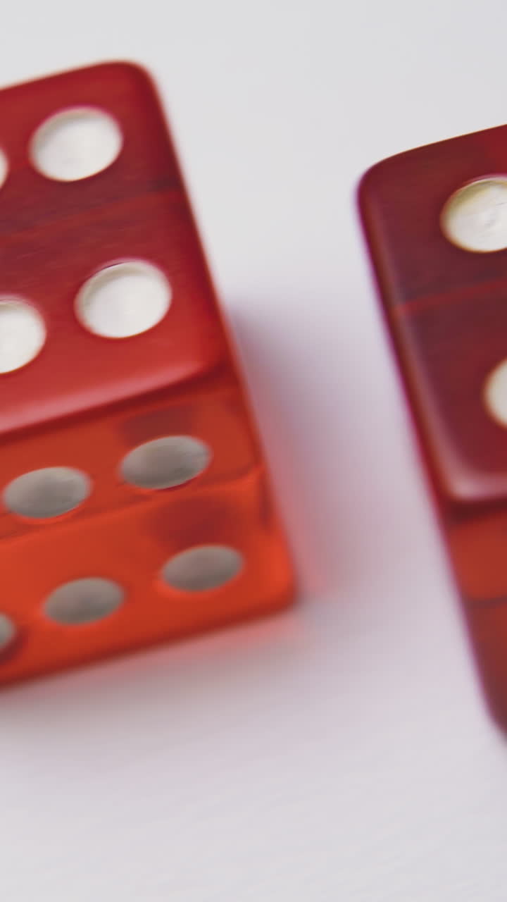 beautiful red transparent plastic dices with white spots lie on light background extreme close view