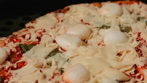 cerrar la sartén de pizza de mozzarella de búfalo con albahaca y base de tomate listo para ir al horno